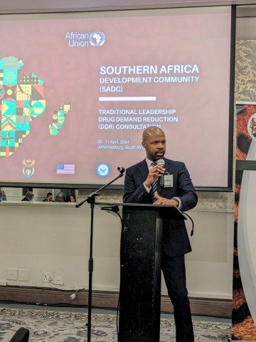 Goodman Sibeko stojí na pódiu a prezentuje jménem ISSUP, ITTC a ICUDDR na jednání Komise Africké unie pro tradiční lídry v oblasti snižování poptávky po drogách
